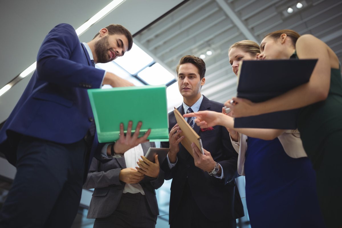 Business executives discussing reports Business executives discussing reports at office