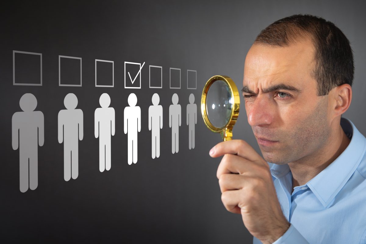 Man holding magnifying glass. Choosing candidate from group. Employee selection recruitment